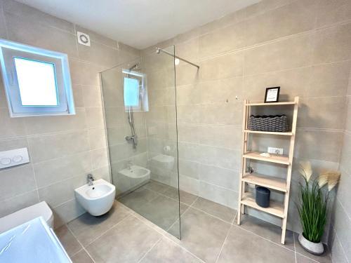 een badkamer met een douche, een toilet en een wastafel bij Villa Palma in Lovran