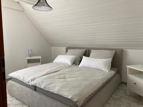 een slaapkamer met een groot bed en een wit plafond bij Ferienhaus Igel in Owingen