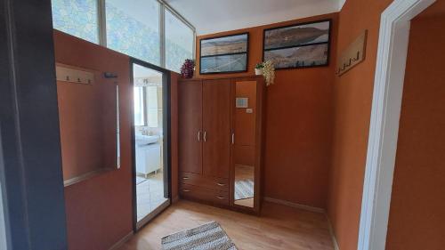 a bathroom with orange walls and a hallway with a mirror at Red blue with private parking and Gray blue apartment in Pula