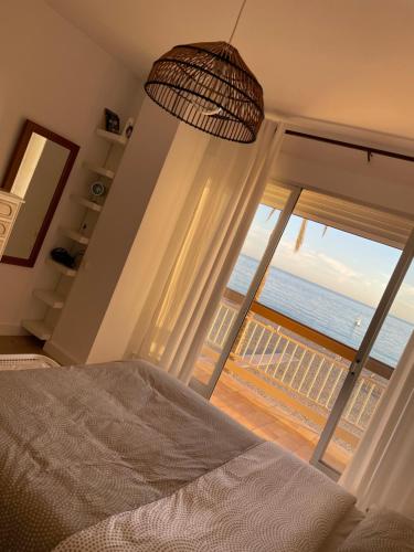 - une chambre avec une grande fenêtre donnant sur l'océan dans l'établissement Primera linea de playa en Torrenueva, à Torrenueva