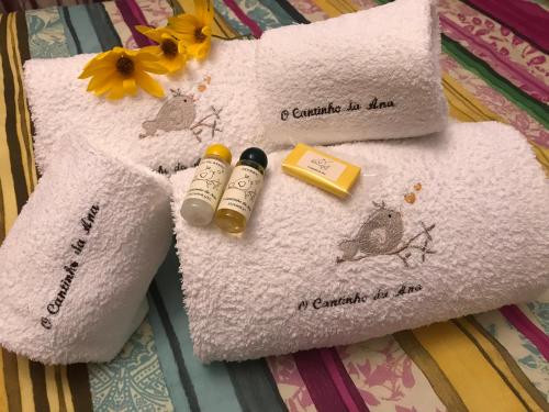 a couple of towels with a bottle of essential oils on them at O Cantinho da Ana in Sortelha