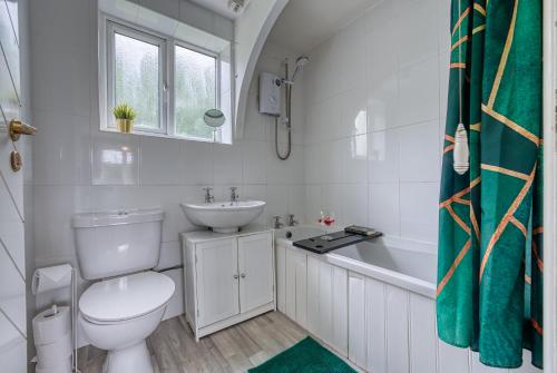 a bathroom with a toilet and a sink and a tub at CAPRI 13 SA - 3 bed House, Close to Loughborough University & M1 motorway, Free Wifi, Big garden, Ample parking- Ask for contractor rates! in Loughborough