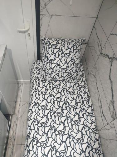 - un lit avec une couette en noir et blanc dans l'établissement Shorty House, à Brétigny-sur-Orge