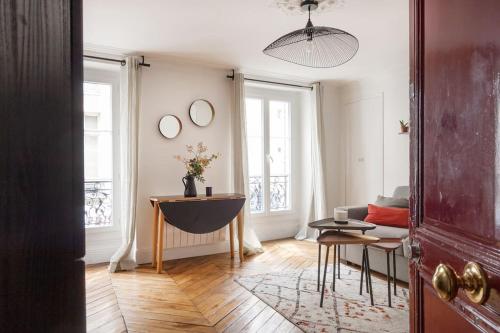 een woonkamer met een bank en een tafel bij CUTE & COSY 1BDR HOTEL DE VILLE / LE MARAIS in Parijs