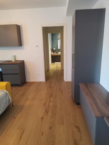 un soggiorno con pavimento in legno e corridoio di B&B Portello Le Terrazze 1 a Milano