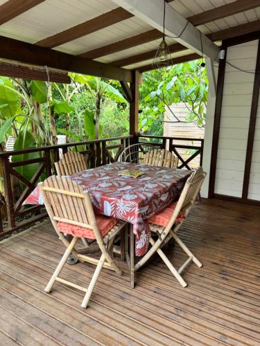 einen Tisch und zwei Stühle auf einer Veranda mit einem Tisch in der Unterkunft Baz créole in Deshaies