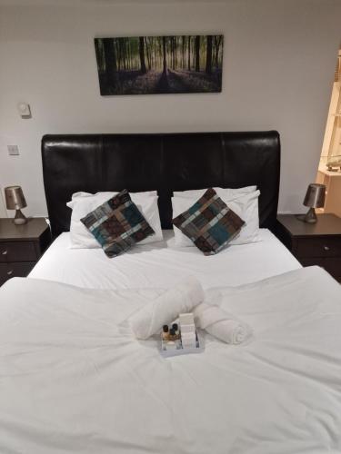 a white bed with two pillows and a book on it at The Granary House - Luxury Stays in Plymouth