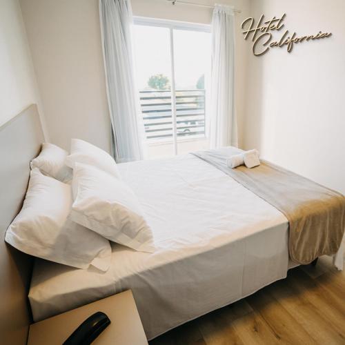 a large white bed in a room with a window at HOTEL CALIFÓRNIA in Concordia