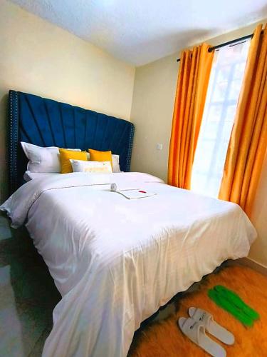 a bedroom with a large white bed with an orange window at DANA HOMES in Nairobi