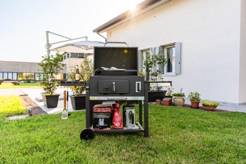 a barbecue grill in the grass in front of a house at TommyHouse in Borso del Grappa