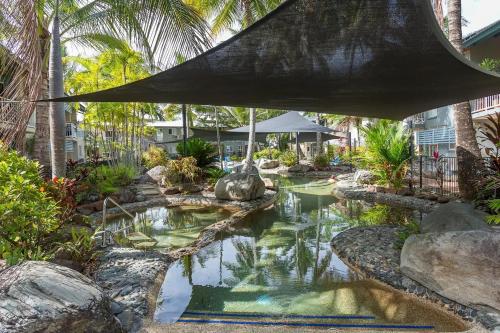 a swimming pool in a resort with palm trees at Trinity Beach Resort 2BR Apt, Pools, 500m to beach in Trinity Beach