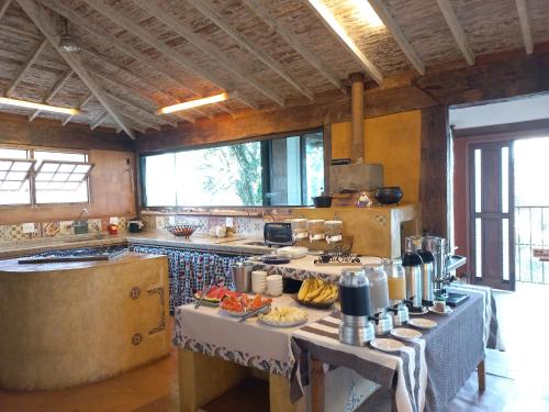 a kitchen with a table with food on it at Pousada Cantares in Tiradentes