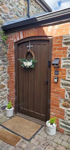 a brown garage door with two flower pots in front of it at The Granary House - Long Stayz in Plymouth
