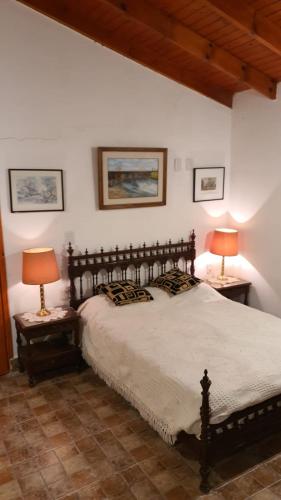 a bedroom with a large bed with two lamps on tables at Casa Quinta La Gualeya in Gualeguay