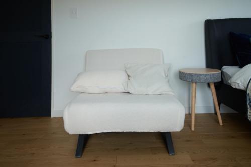 a white chair with two pillows on top of it at Villacation the Loose in Minamiawaji