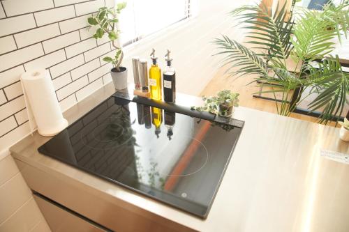 a kitchen counter with wine bottles on a counter top at Villacation the Loose in Minamiawaji