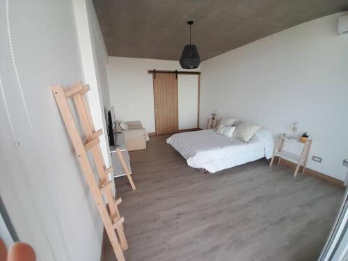 a bedroom with a bed and a wooden floor at Northbeach, Pinamar in Costa Esmeralda