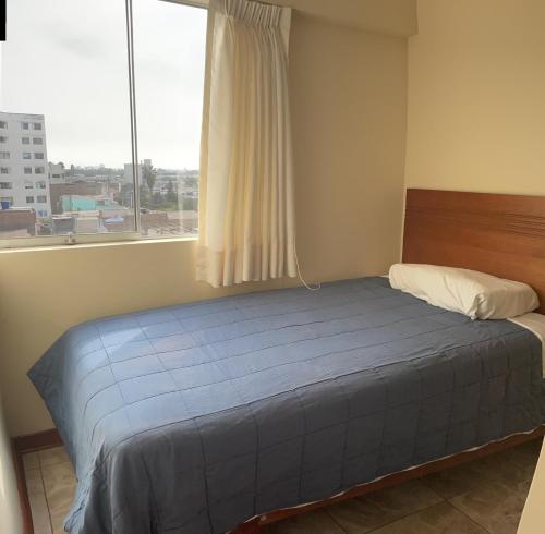 uma cama num quarto com uma grande janela em santa emma 701 em Lima