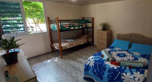 a bedroom with a bed and a bunk bed at PENSION TOKA EVA in Nuku Hiva