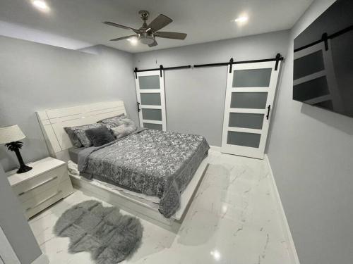 a white bedroom with a bed and a fan at Villa Sosa in Fort Myers