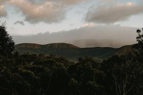 a view of a mountain range with a cloudy sky at Mill Cabin —Luxury Granite Cabin, Mountain views in Crackenback