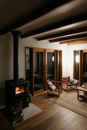 a living room with a woodburning stove in a room at Mill Cabin —Luxury Granite Cabin, Mountain views in Crackenback