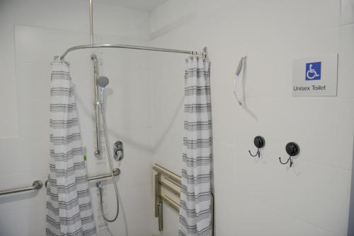 a shower with a shower curtain in a bathroom at The Big Bell Farm in Kangaroo Valley