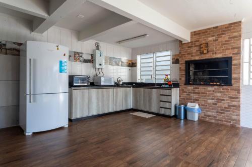 eine Küche mit einem weißen Kühlschrank und einer Ziegelwand in der Unterkunft Casa confortável e aconchegante in Bento Gonçalves