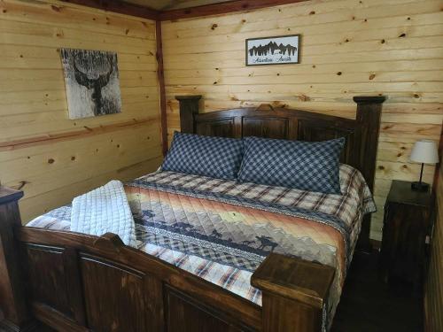 - une chambre avec un lit dans une cabane en rondins dans l'établissement Halfmoon Hideaway-Cozy 2 bdr cabin Mena AR, à Mena