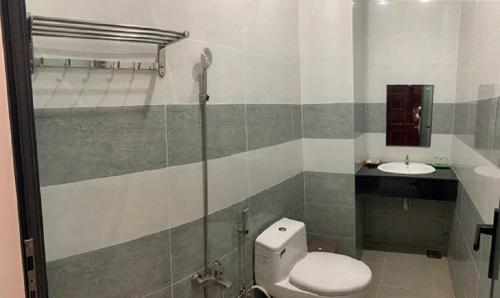 ein Bad mit einem WC und einem Waschbecken in der Unterkunft Khách Sạn HOÀNG KIM in Bạc Liêu