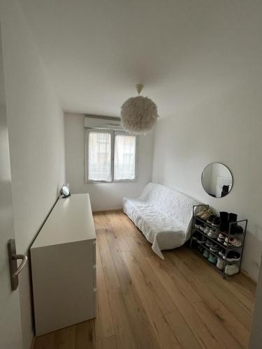 - une chambre blanche avec un lit et du parquet dans l'établissement castle apartment, à Maisons-Alfort
