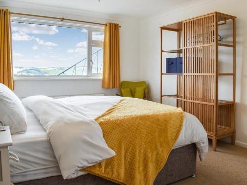 a bedroom with a large bed and a window at The Dawn in Looe