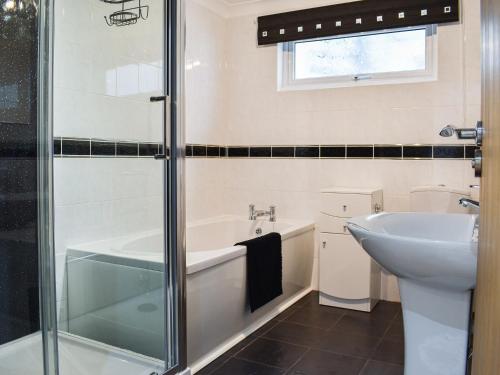 a bathroom with a bath tub and a sink at The Dawn in Looe