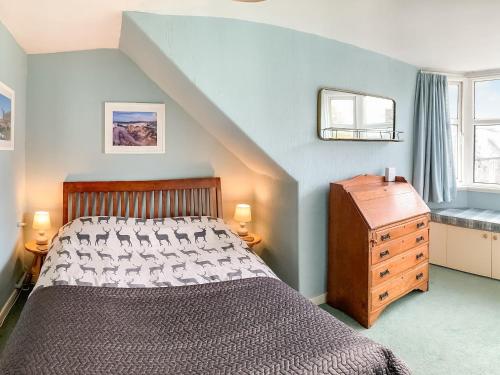 a bedroom with a bed and a wooden dresser at Cochrane House in Kirkcudbright
