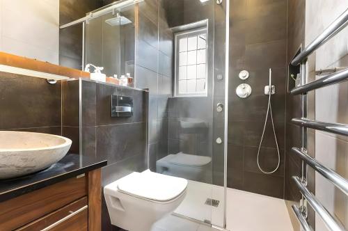 a bathroom with a shower and a toilet and a sink at Exclusive Apartment in Greater London in Croxley Green