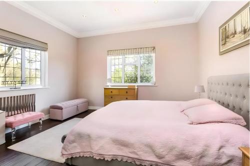 a bedroom with a large bed and two windows at Exclusive Apartment in Greater London in Croxley Green