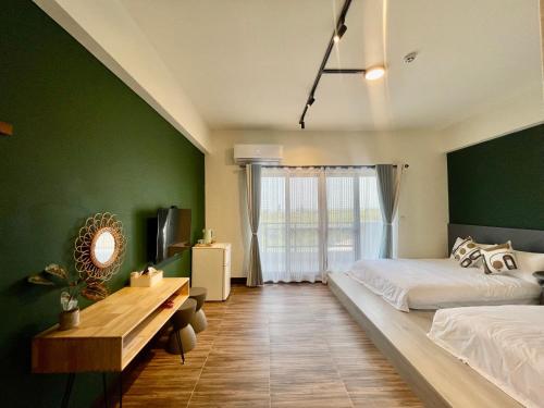 1 dormitorio con 2 camas y pared verde en Mian Bao Homestay en Magong