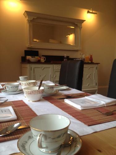 a table with bowls and cups on top of it at Creity Hall Guest House in Doune