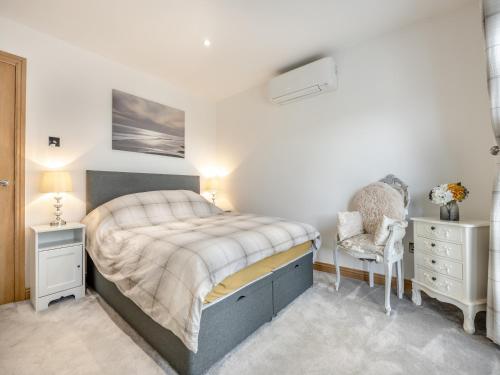 a bedroom with a large bed and a chair at The Hideaway in Chapel Saint Leonards