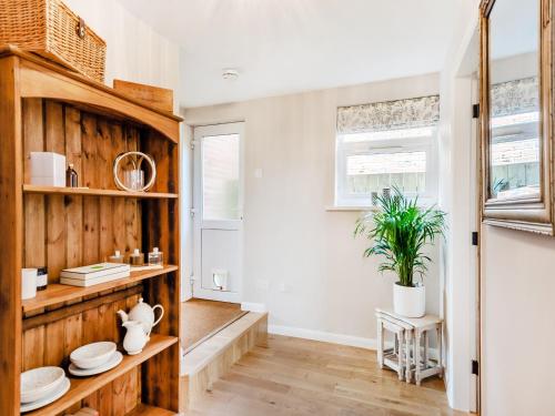 uma cozinha com prateleiras de madeira e uma planta em Wheelwrights Cottage em Yeaveley