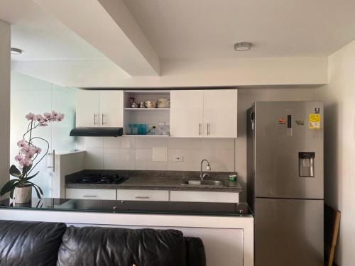 una cocina con nevera de acero inoxidable y armarios blancos en Apartamento en Pereira excelente ubicación, en Pereira