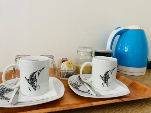 two coffee cups and saucers on a wooden tray at Poe Guesthouse in Avatoru