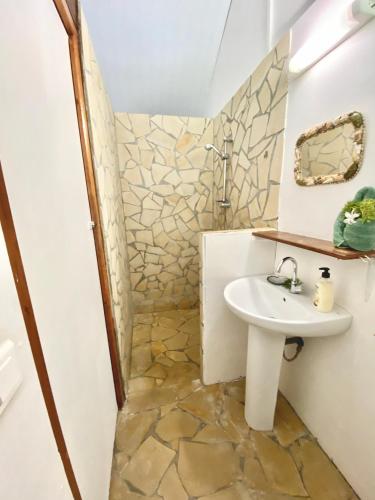 La salle de bains est pourvue d'un lavabo et d'un miroir. dans l'établissement Poe Guesthouse, à Avatoru
