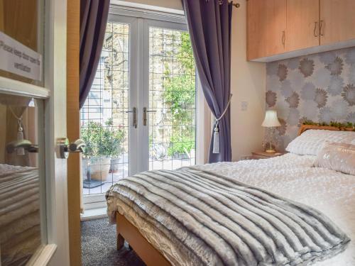 a bedroom with a bed and a large window at Lilly Lodge in Almondbury