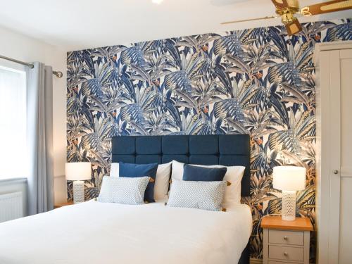 a bedroom with a large bed with a blue headboard at Askham House in York