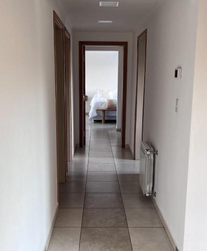 an empty hallway with a bed in a bedroom at Villa Soñada - Encantadora Casa para 6 Personas in Esquel
