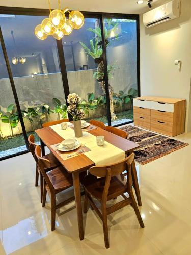 Un comedor con mesa y sillas de madera. en Rania Guest House, en Salakan