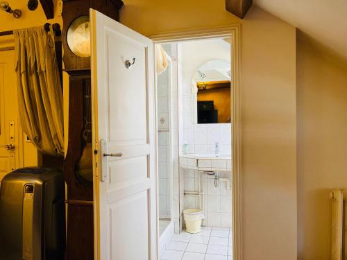 ein Badezimmer mit einer weißen Tür und einem Waschbecken in der Unterkunft LE JARDIN DU VENDOME in Tours