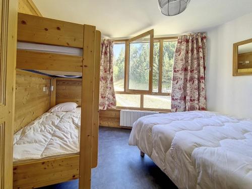une chambre avec deux lits superposés et une fenêtre dans l'établissement Appartement spacieux avec balcon orienté Sud, au pied des pistes, proche La Croisette. - FR-1-344-1177, aux Menuires