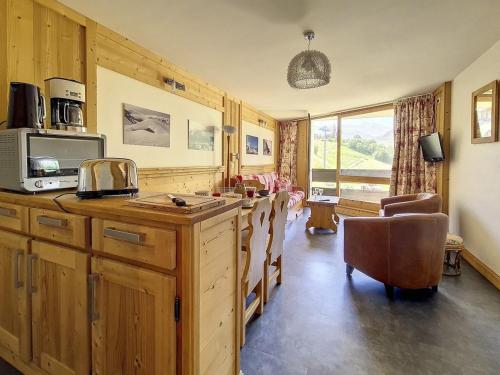 une cuisine avec un comptoir avec un micro-ondes dans l'établissement Appartement spacieux avec balcon orienté Sud, au pied des pistes, proche La Croisette. - FR-1-344-1177, aux Menuires